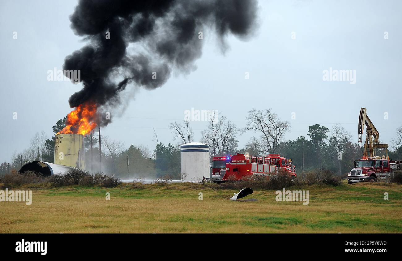 Firefighters from three volunteer departments use suppressant foam to  extinguish a fire in a salt water storage tank at a natural gas well near  Nacogdoches, Texas, on Tuesday, Dec. 4, 2012. Katie