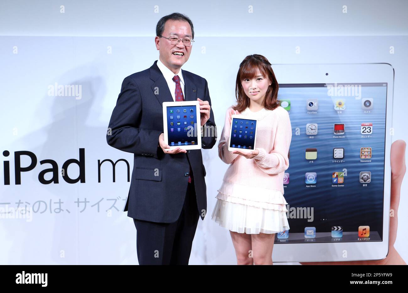 KDDI's president Takashi Tanaka L with a new iPad 4 and