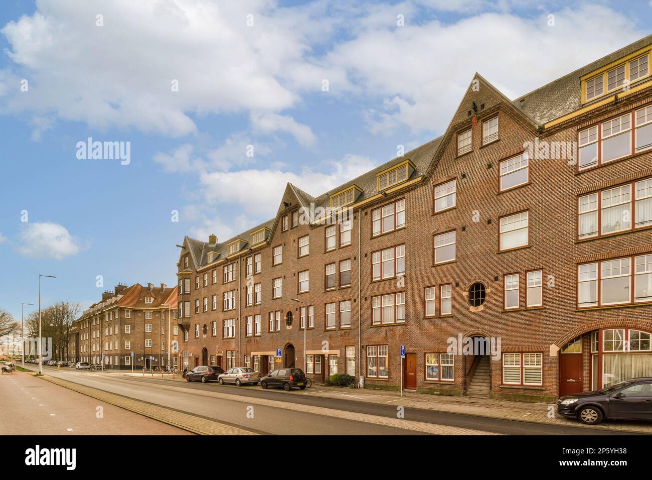 a city street with cars parked on the side and buildings in the middle ...