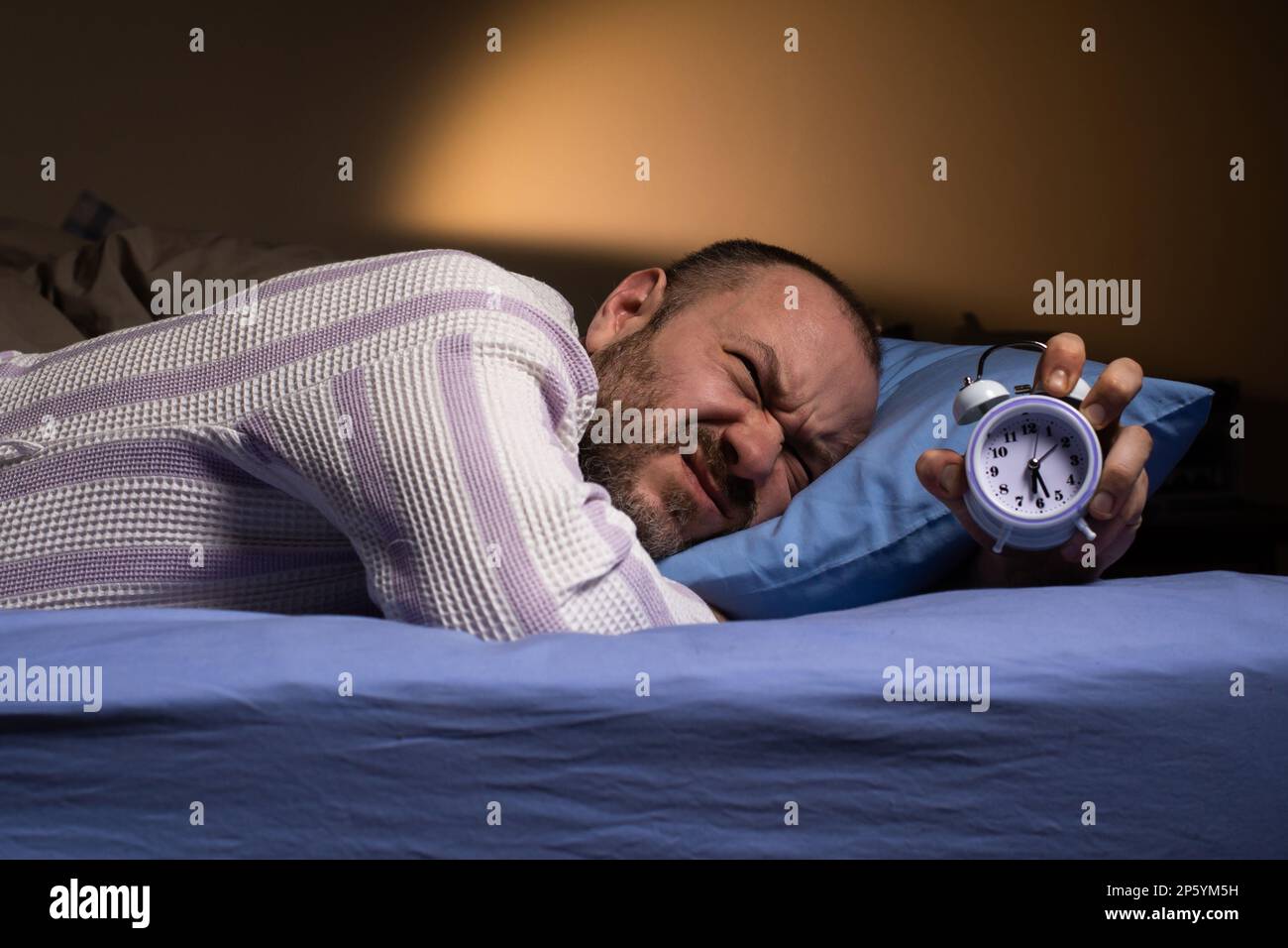 Annoying alarm clock in the morning. Dislike waking up in the morning. The  man is aggressively awakened by the ringing of the alarm clock. Hateful mor  Stock Photo - Alamy