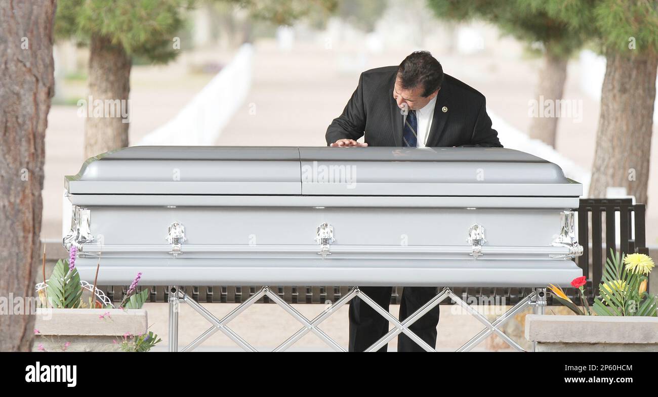 An unidentified man touches the casket Sherman Hemsley who was buried