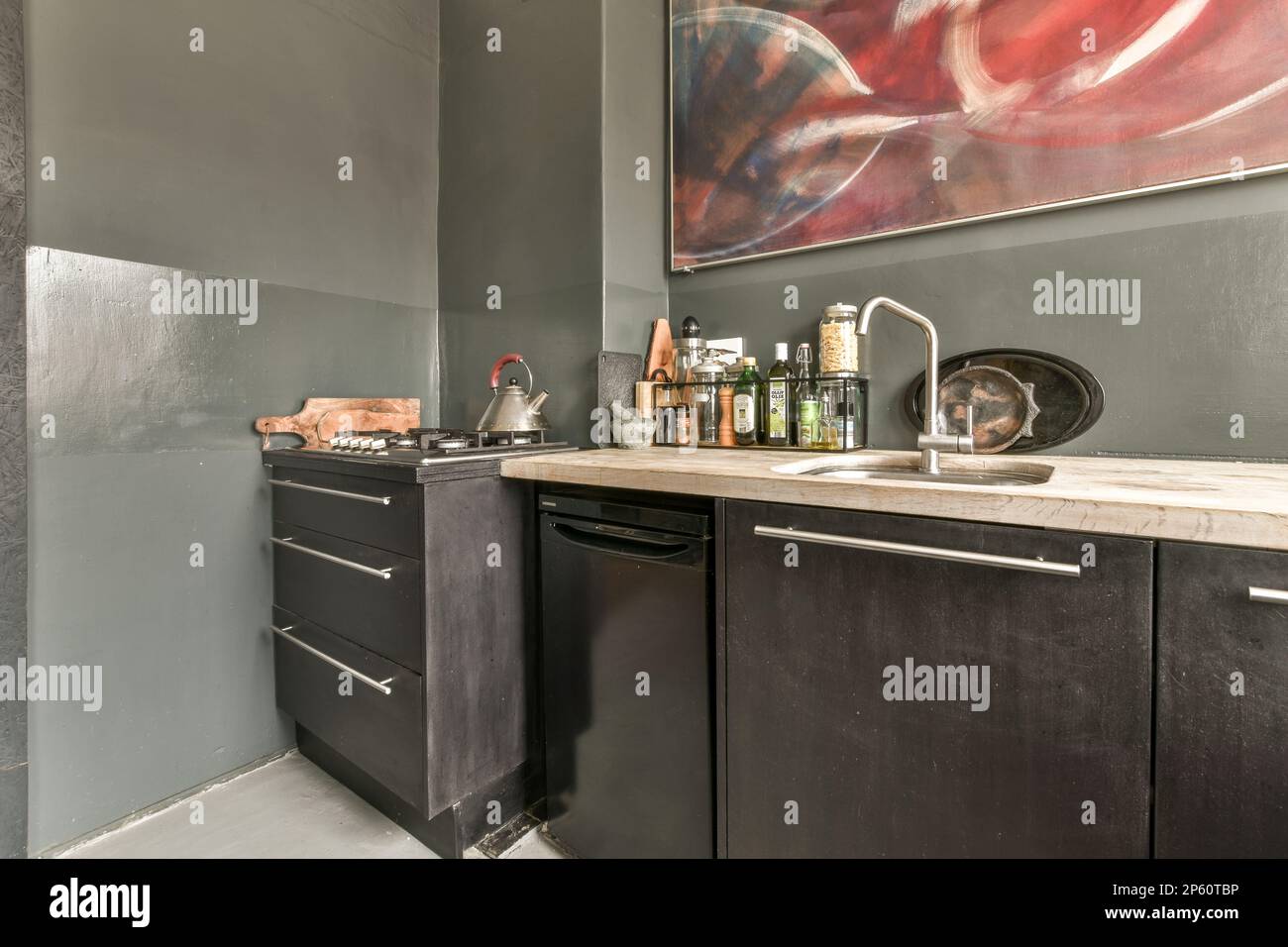 an abstract painting on the wall in a kitchen with black cabinets and ...