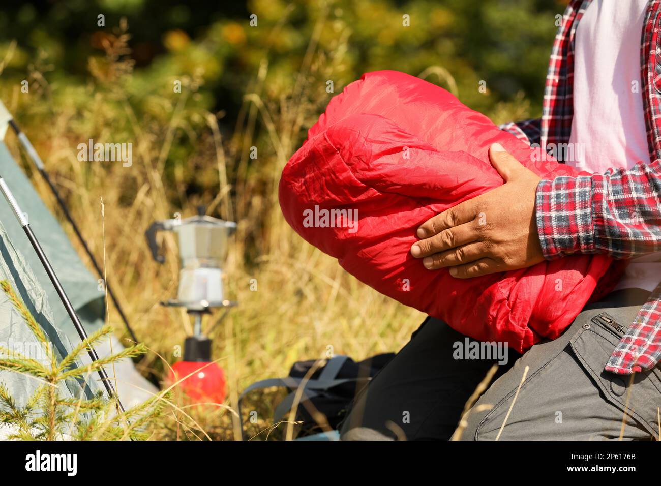 Tourist packing red sleeping bag outdoors, closeup Stock Photo - Alamy
