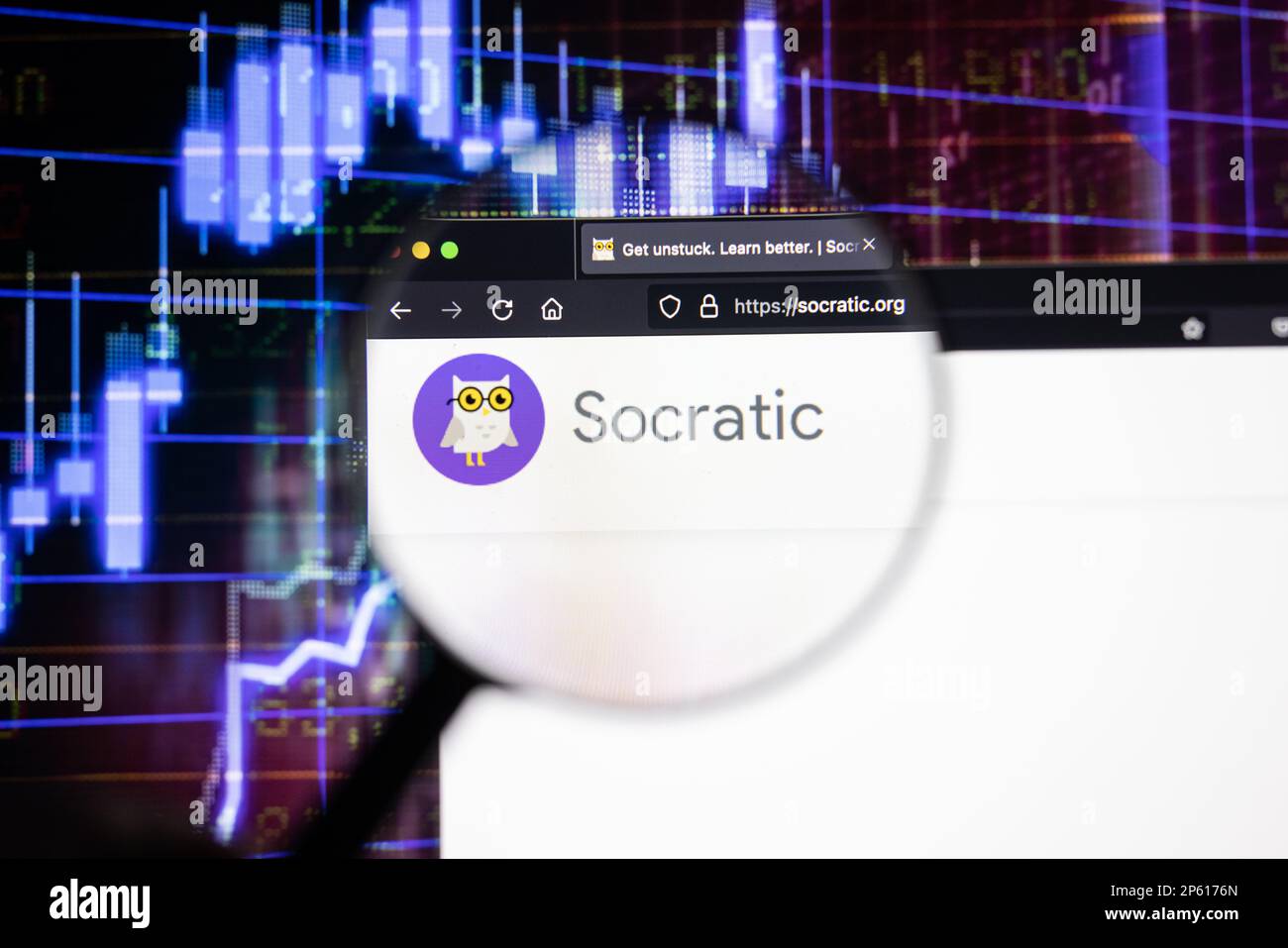 Socratic company logo on a website with blurry stock market developments in the background, seen on a computer screen through a magnifying glass Stock Photo