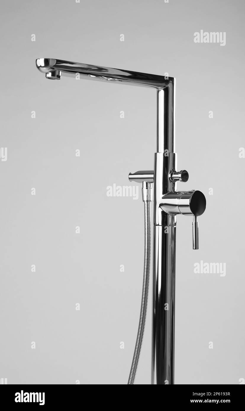 Modern bathtub faucet with hand shower on grey background Stock Photo