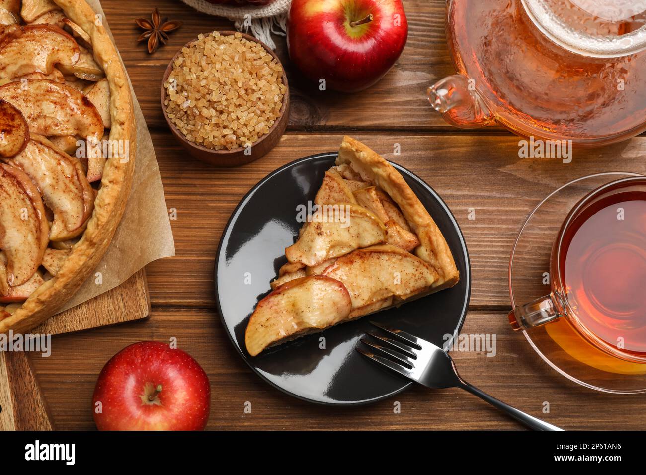 Delicious apple pie served with tea on wooden table, flat lay Stock Photo