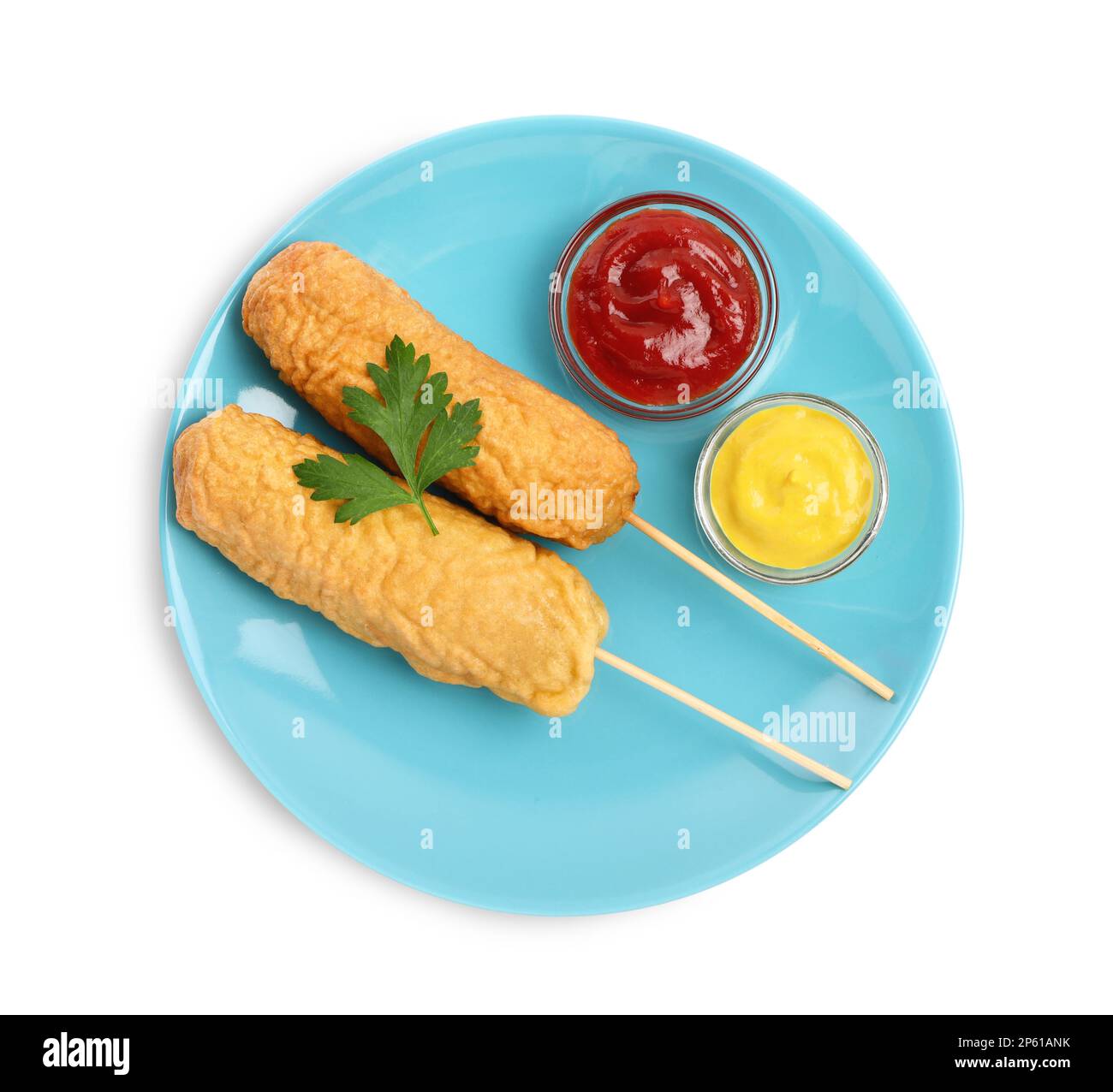 Delicious deep fried corn dogs with parsley and sauces on white