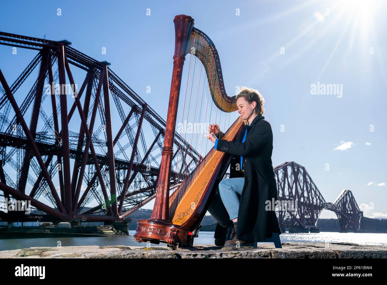 Composer, harpist and singer Esther Swift plays her Italian Salvi pedal harp during a photocall ahead of her upcoming tour, at the Forth Bridge in North Queensferry. Ms Swift will tour across Scotland solo this month with a programme of original compositions and traditional works. Picture date: Tuesday March 7, 2023. Stock Photo