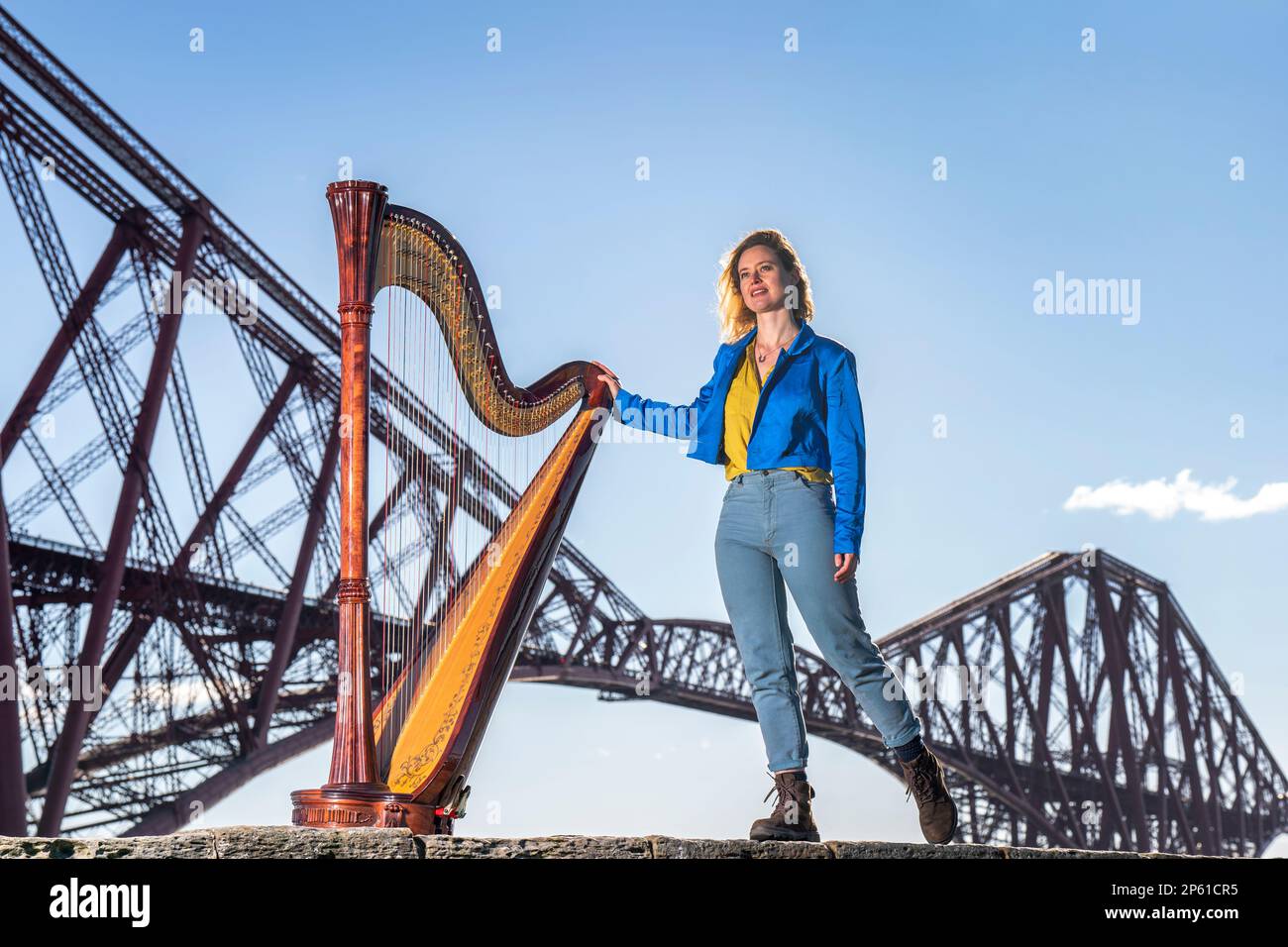 Composer, harpist and singer Esther Swift alongside her Italian Salvi pedal harp during a photocall ahead of her upcoming tour, at the Forth Bridge in North Queensferry. Ms Swift will tour across Scotland solo this month with a programme of original compositions and traditional works. Picture date: Tuesday March 7, 2023. Stock Photo