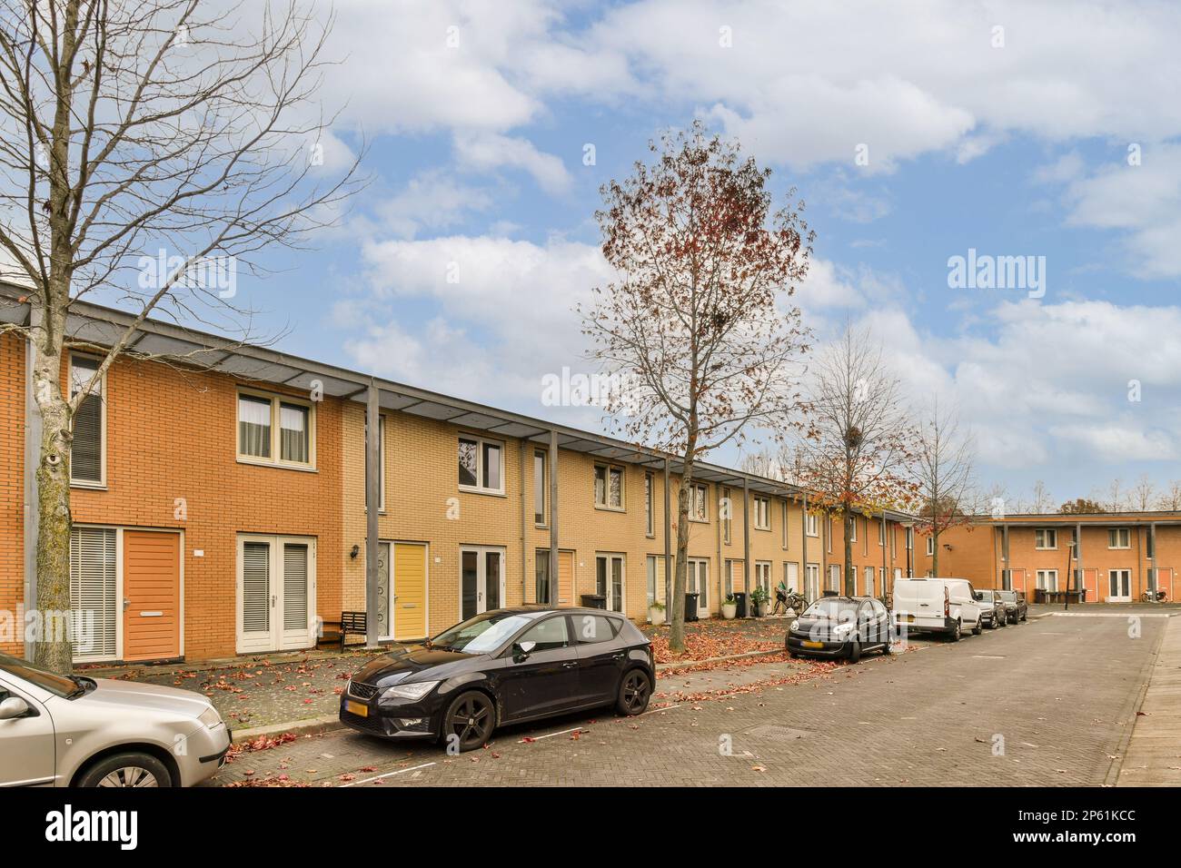 an apartment complex with cars parked in the driveway and trees on ...
