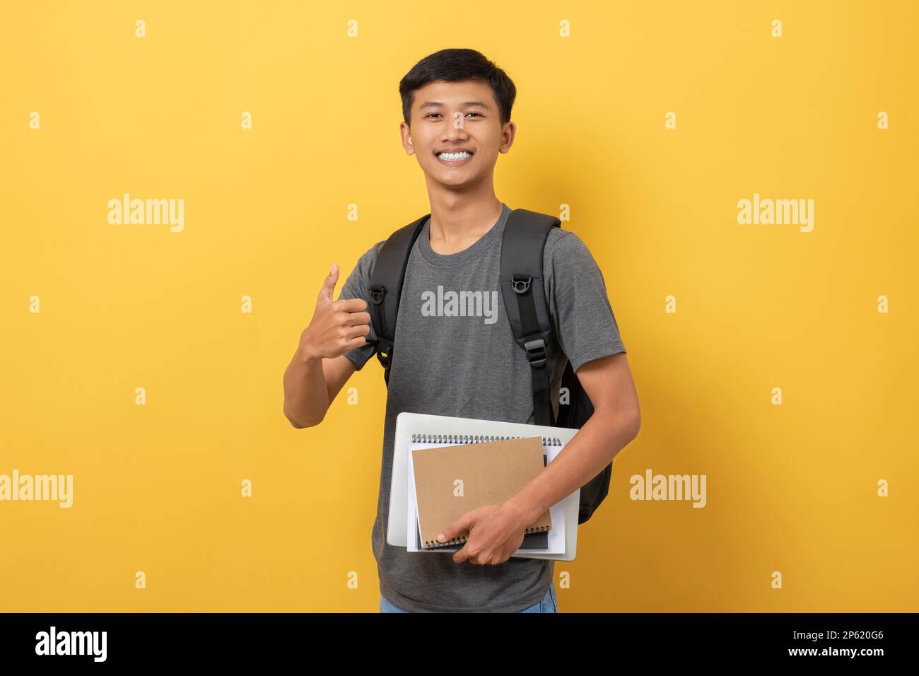 Smiling young college student with books and backpack isolated on ...