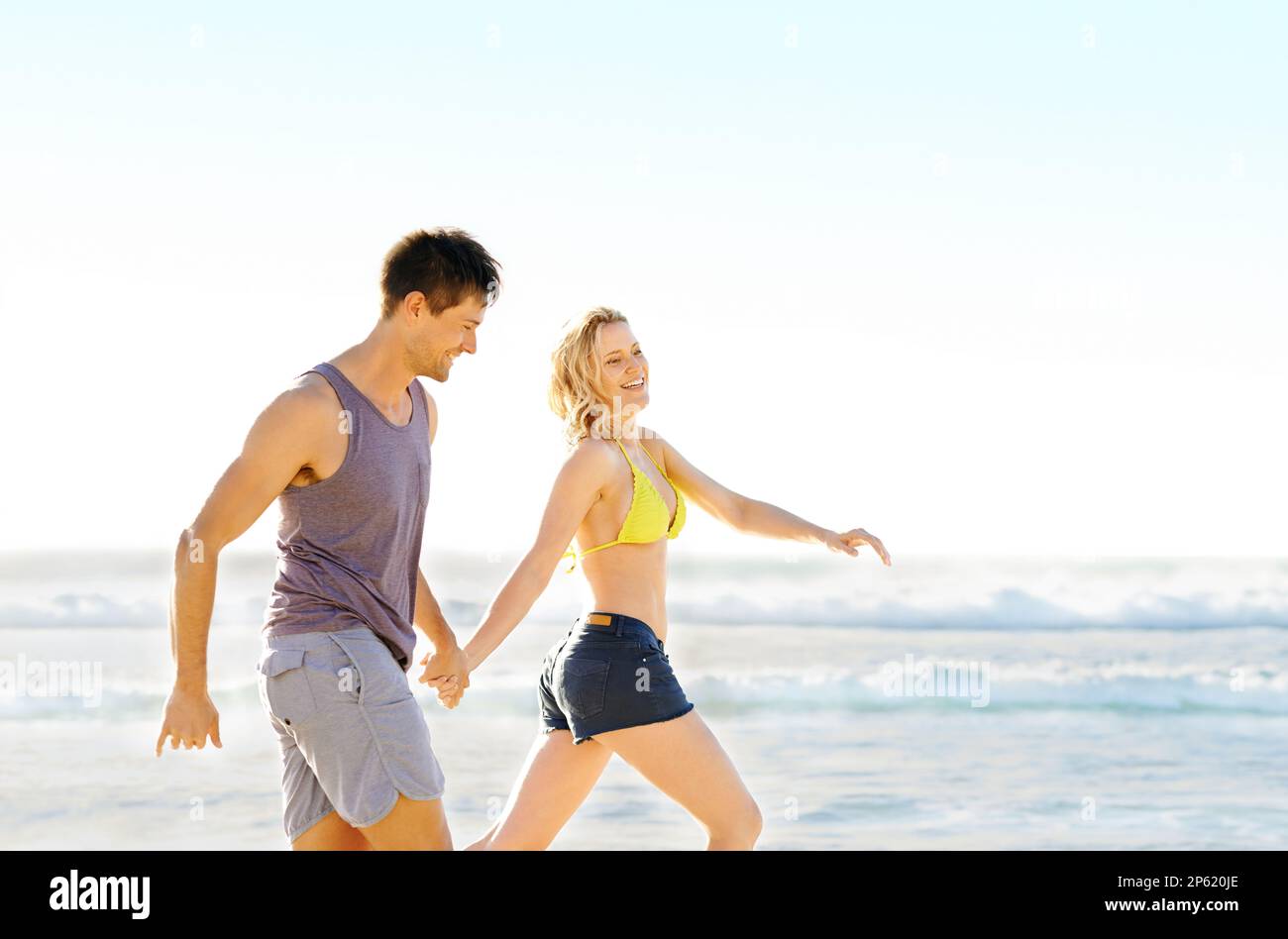 Attractive Couple Playing At The Sea. Girl Flirts With Her Boyfriend: She  Took His Swimming Trunks And Runs Away From Him Stock Photo, Picture and  Royalty Free Image. Image 93837530.