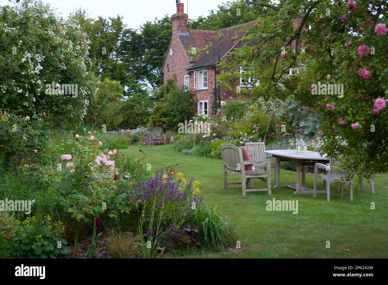 beautiful summer garden in English country house with table and chairs