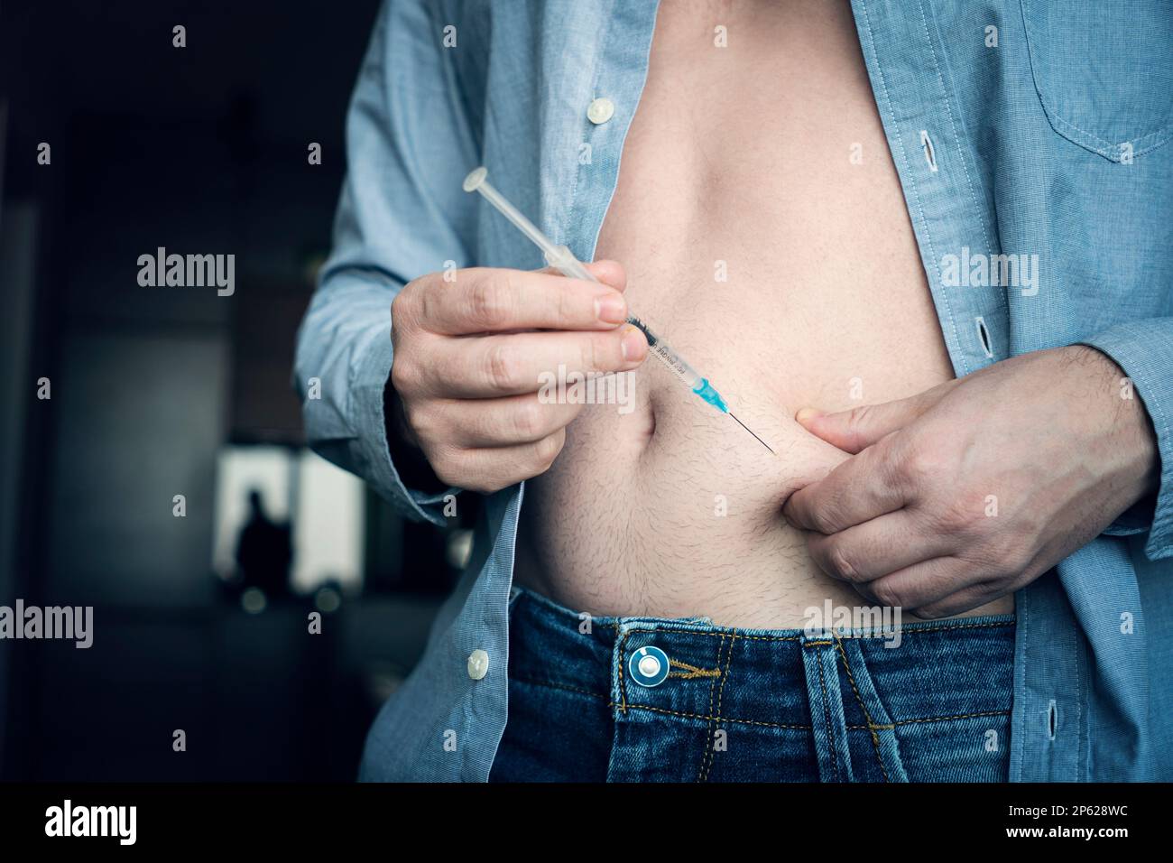 young man hand using insulin syringe close up . injecting insulin at home. self-medication Stock Photo