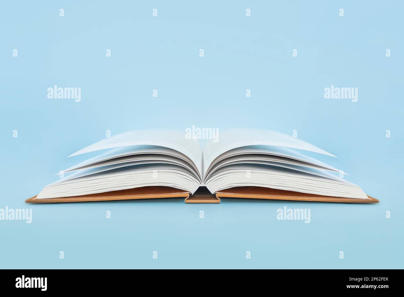 Open book with hard cover on blue background Stock Photo