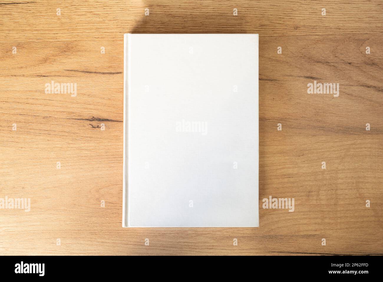 a white book with an empty pesto for text and design on a wooden background Stock Photo