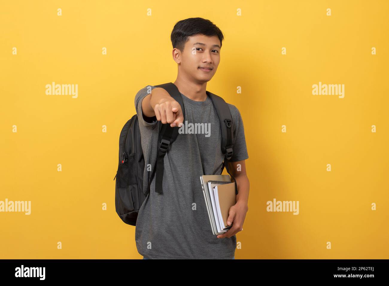 Smiling young college student with books and backpack isolated on ...