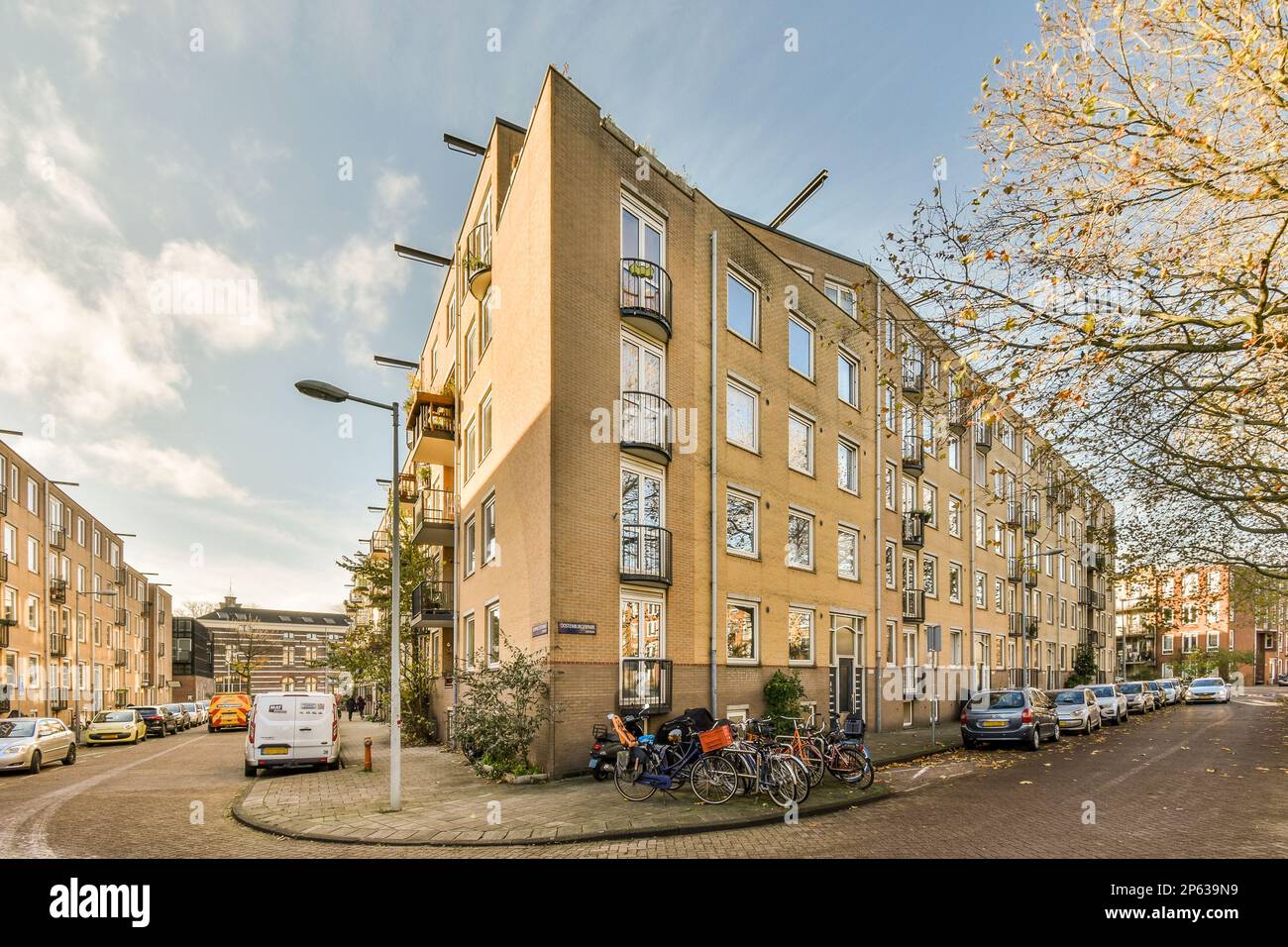 a city street with parked cars and bicycles on the side of the road, in ...