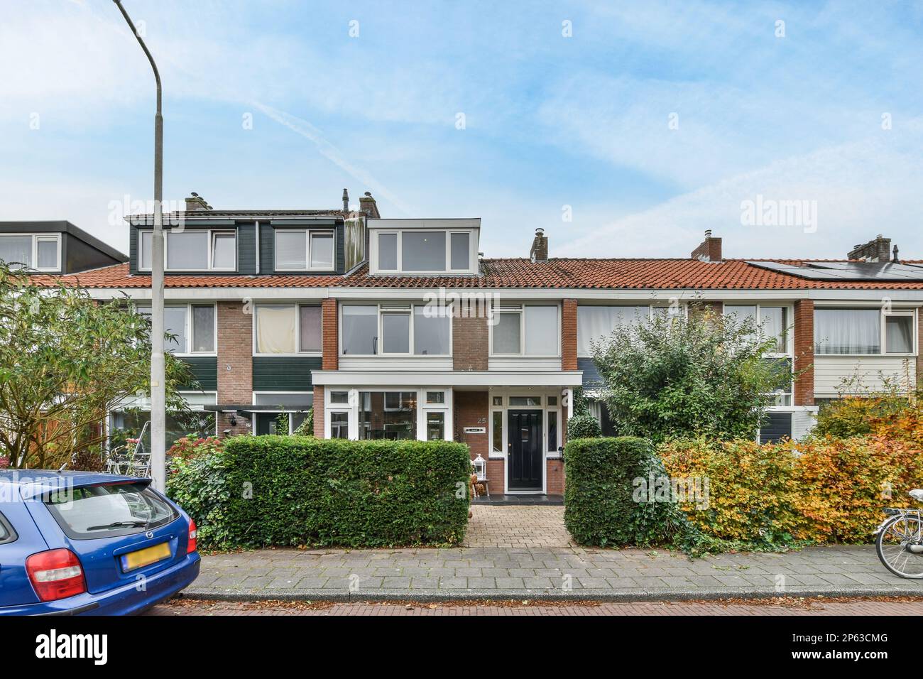 some houses with cars parked on the street in front of them and one car ...