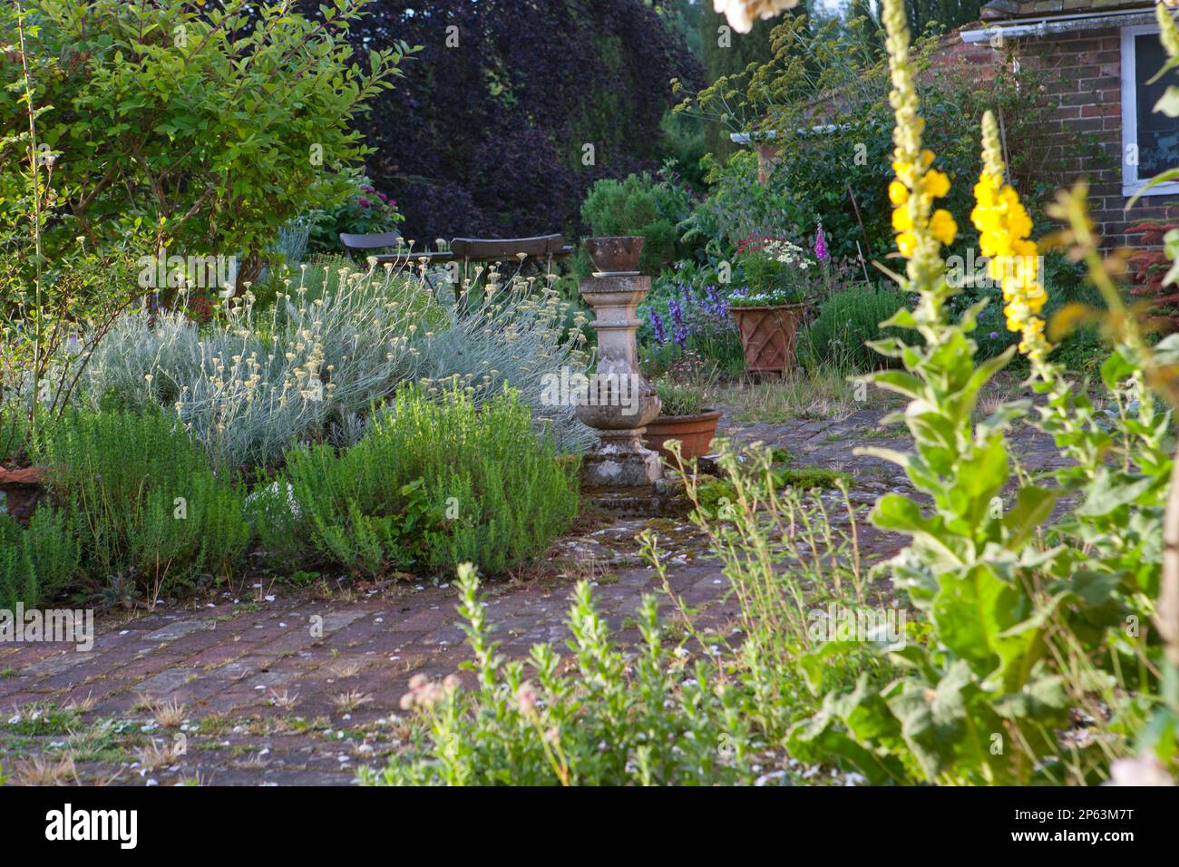 small cottage garden with brick paving in late summer Stock Photo