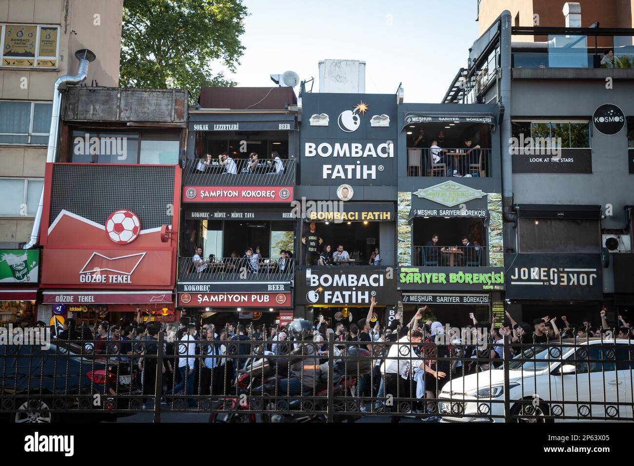 Picture of bars in the district of Besiktas  in Istanbul, Turkey, with supporters passing in front supporting besiktas JK. Beşiktaş Jimnastik Kulübü, Stock Photo