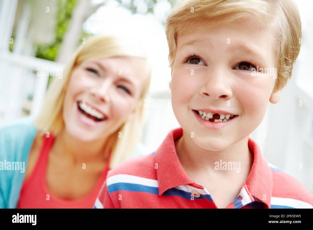 Mom said I was brave when they fell out. A young boy with a missing tooth spending time with his mother. Stock Photo