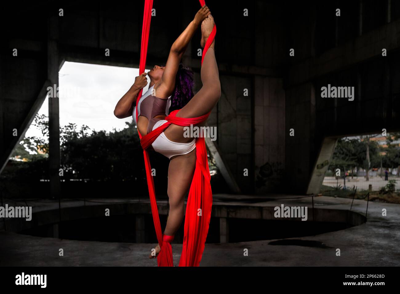 Mariale Contreras, a Venezuelan aerial dancer, performs on aerial silks during an art performance in an industrial space in Barranquilla, Colombia. Stock Photo