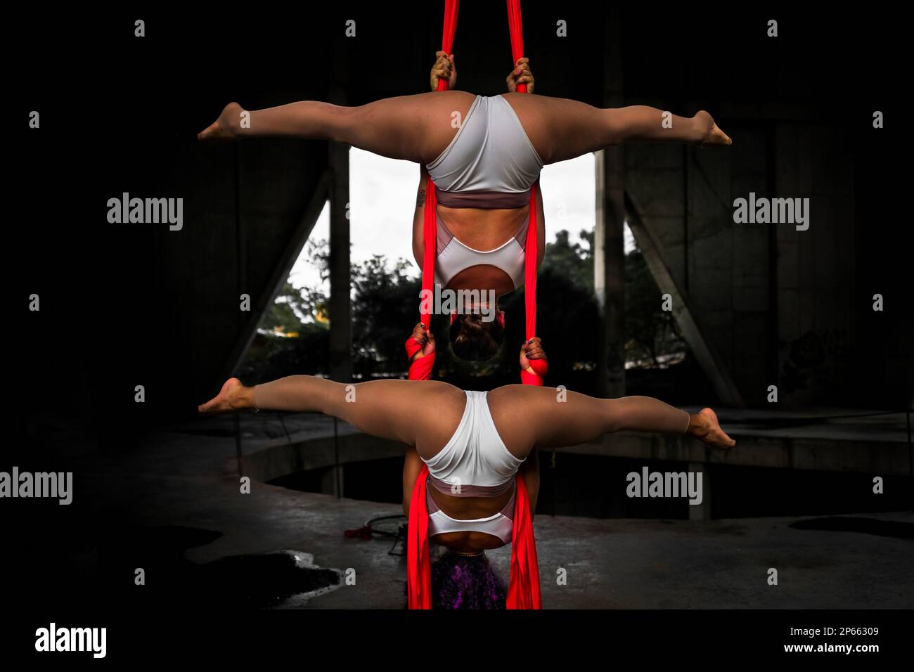 Shara Guzman and Mariale Contreras, Venezuelan aerial dancers, perform a duo act on aerial silks during an art performance in Barranquilla, Colombia. Stock Photo