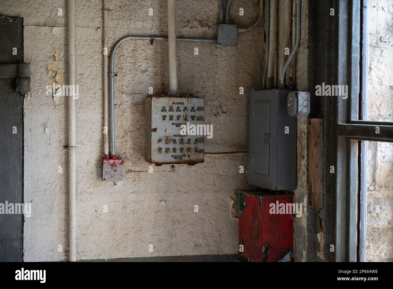 The inside of an old Joliet Prison with a red box and a variety of electrical components Stock Photo