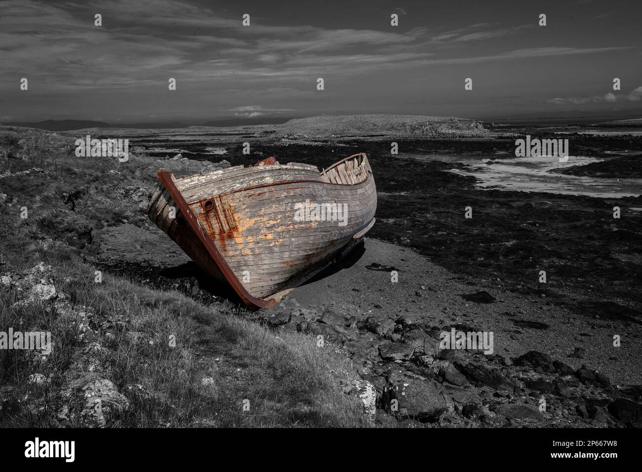 Artistic rendition of a wrecked wooden boat in a bay in Iceland against a monochrome background Stock Photo