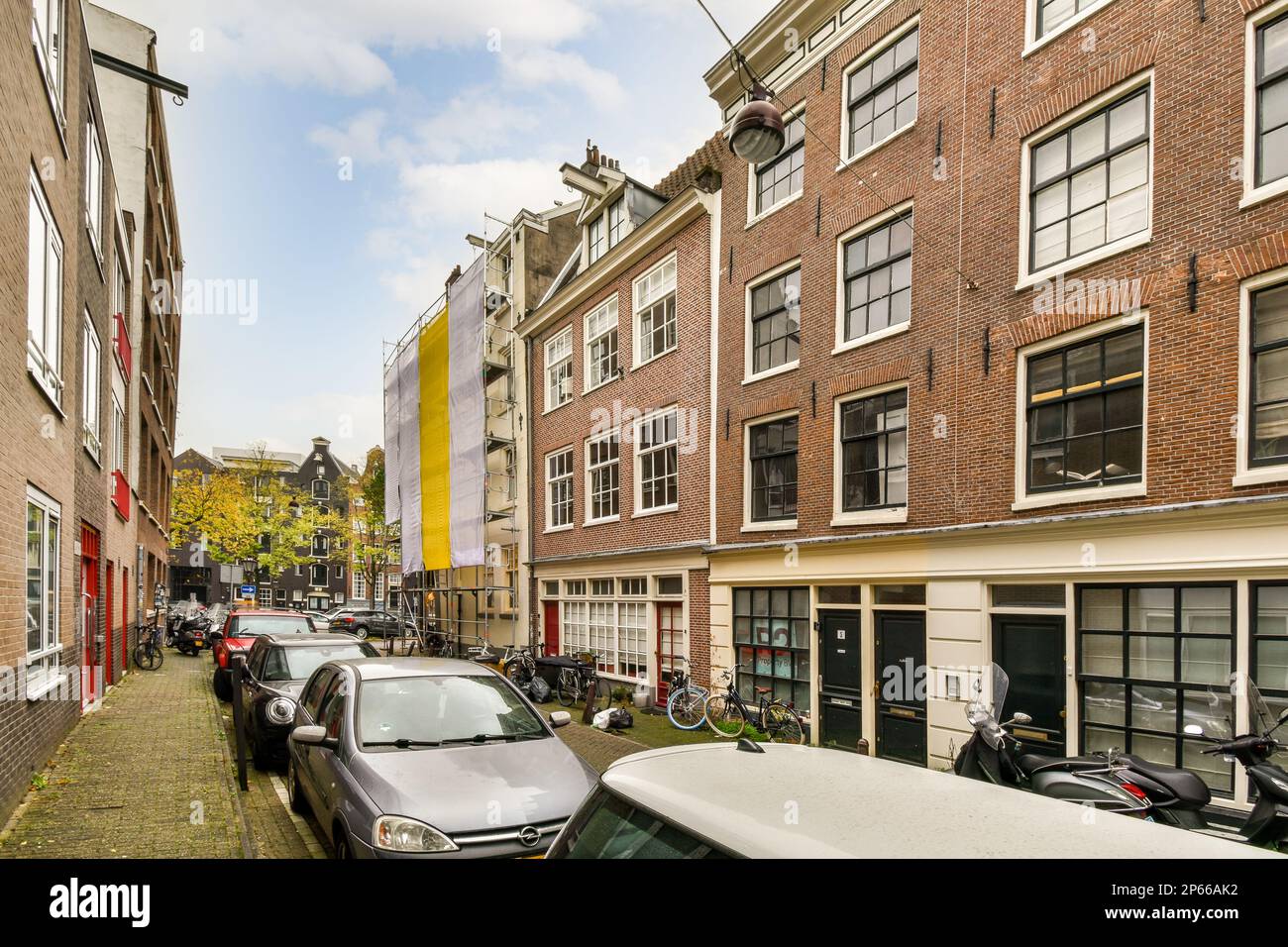 some cars parked on the side of a street in an urban area with tall ...