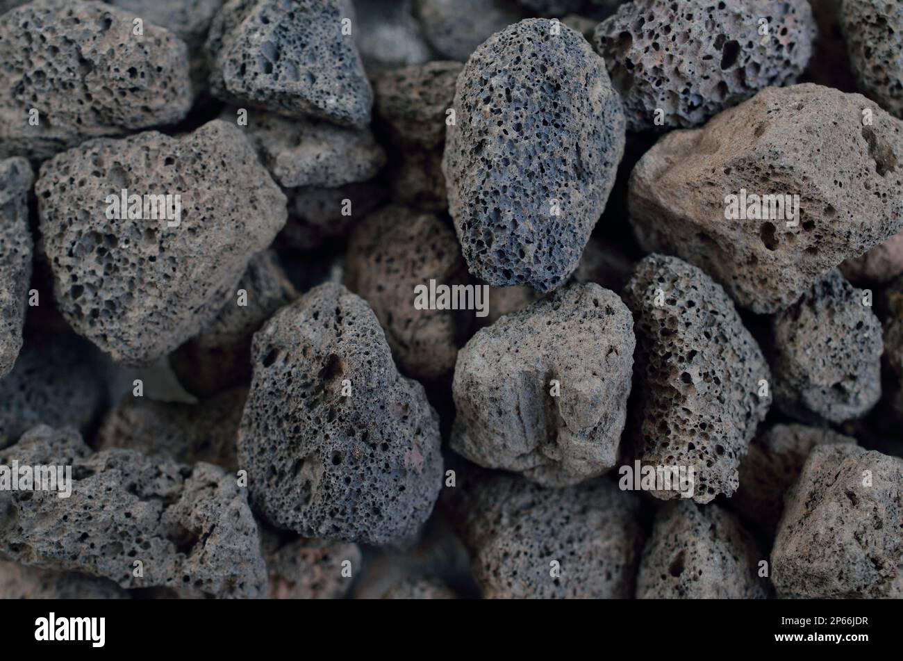 Porous black volcanic rock isolated on white background. Lava stone