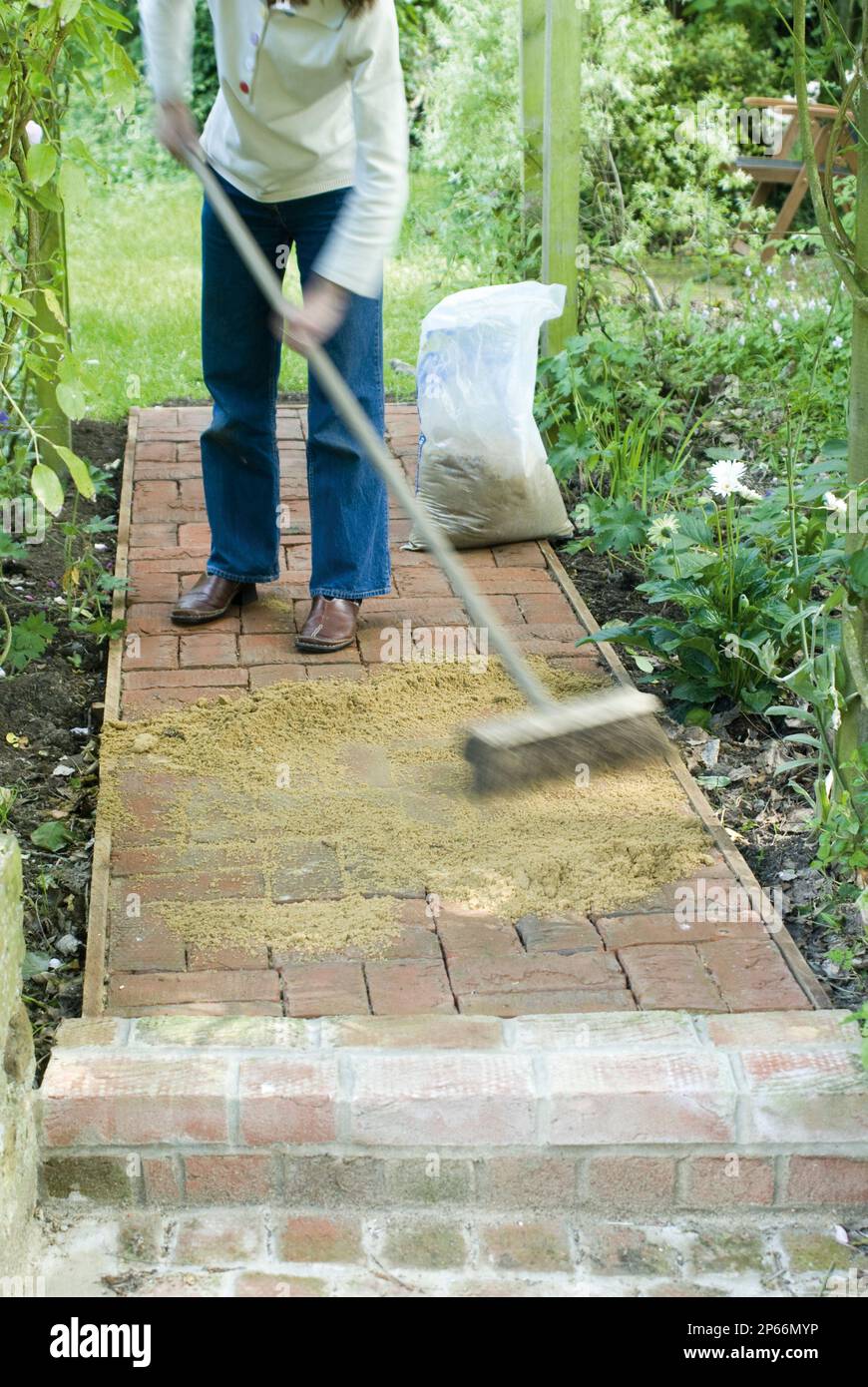Making a brick garden pathway brushing in grouting filling joints