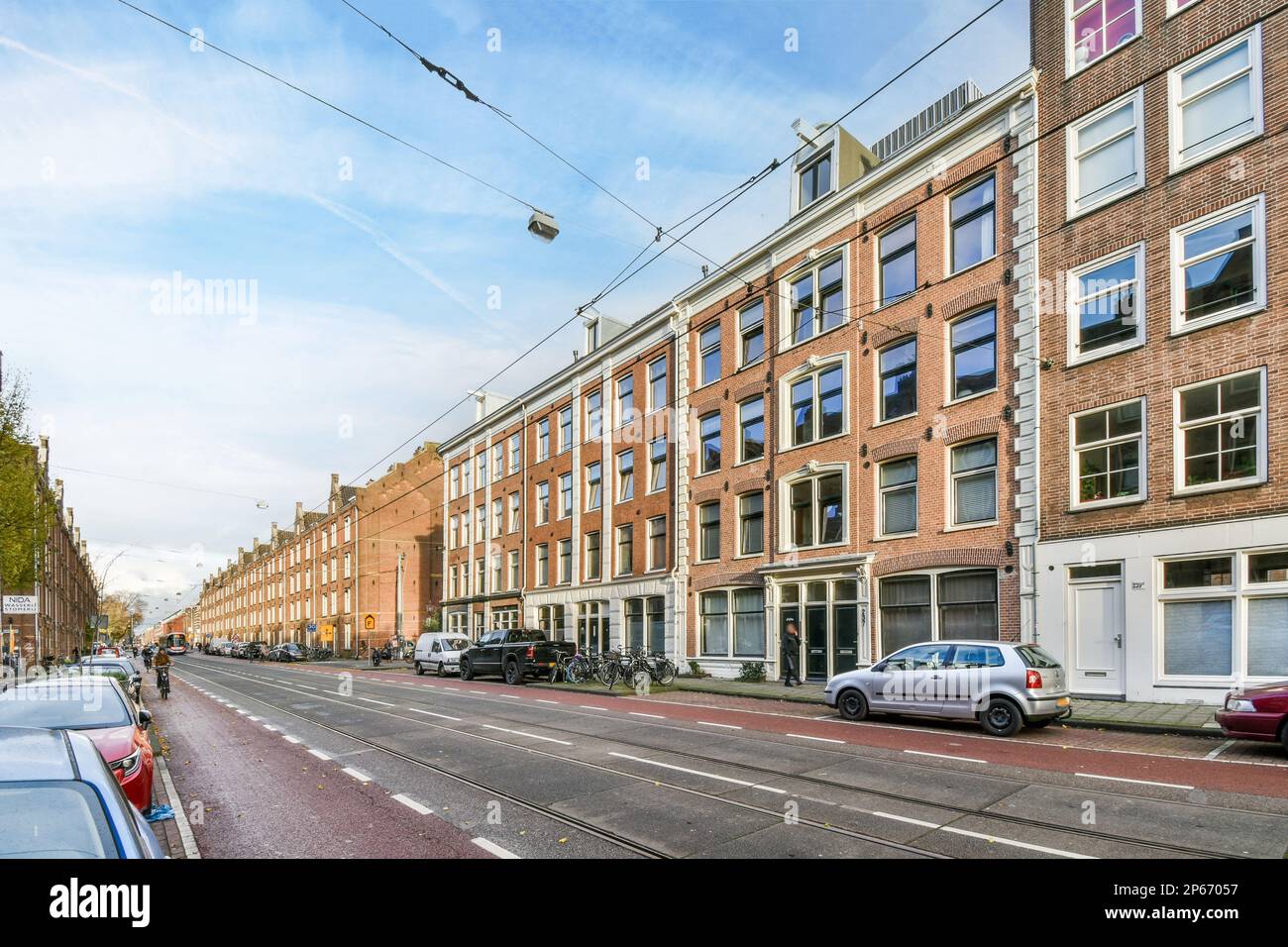 a city street with cars parked on the side and buildings in the ...