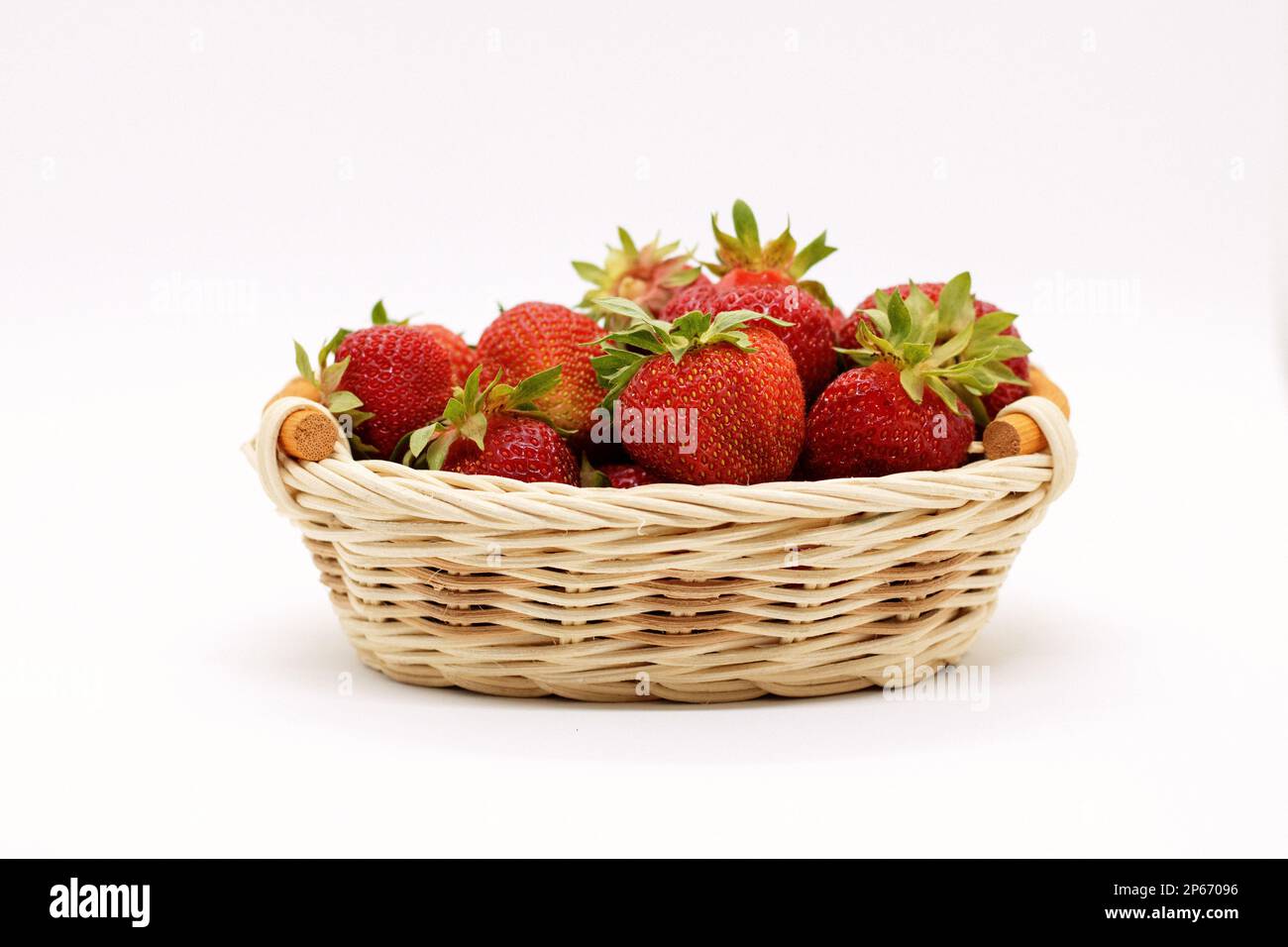 composition of ripe strawberries on a white background in a wicker ...