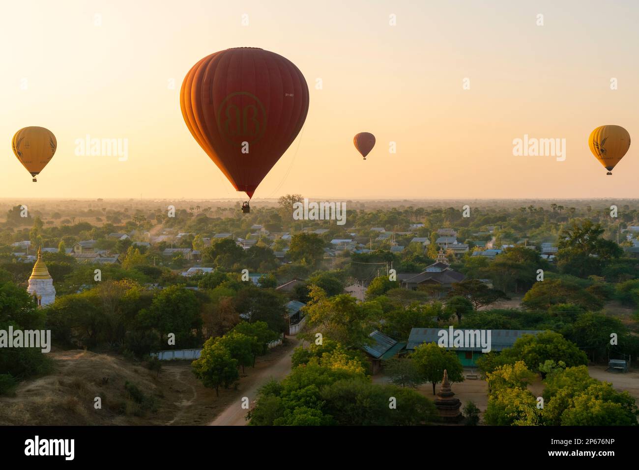 Hot-air balloons at sunrise over village near Bagan (Pagan), Myanmar (Burma), Asia Stock Photo