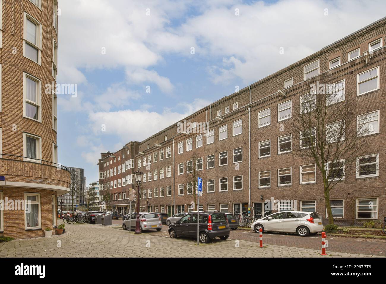 a street with cars parked on the side and buildings in the back ground ...