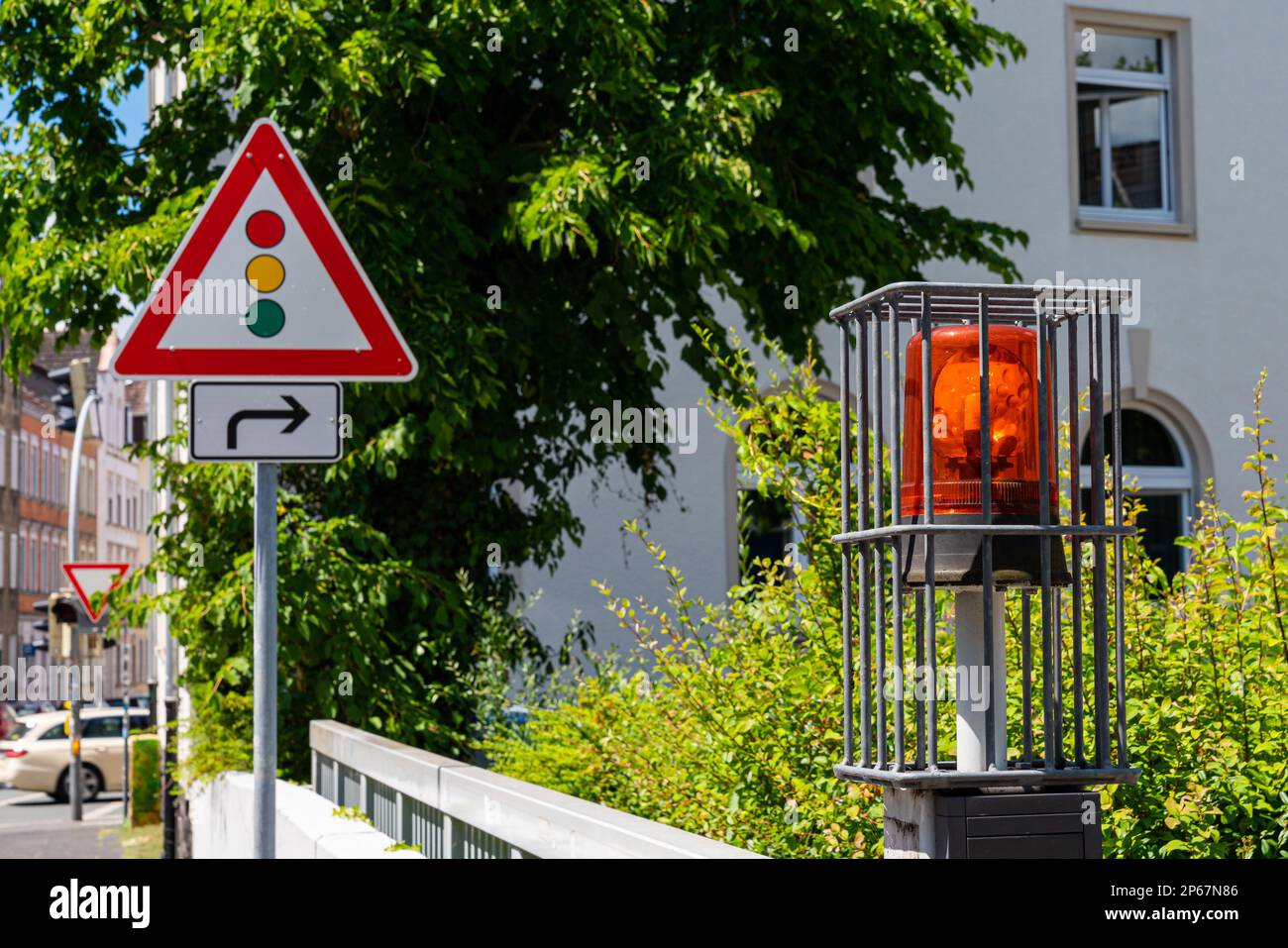Flashing orange signal at the gate. Road sign indicating approaching a