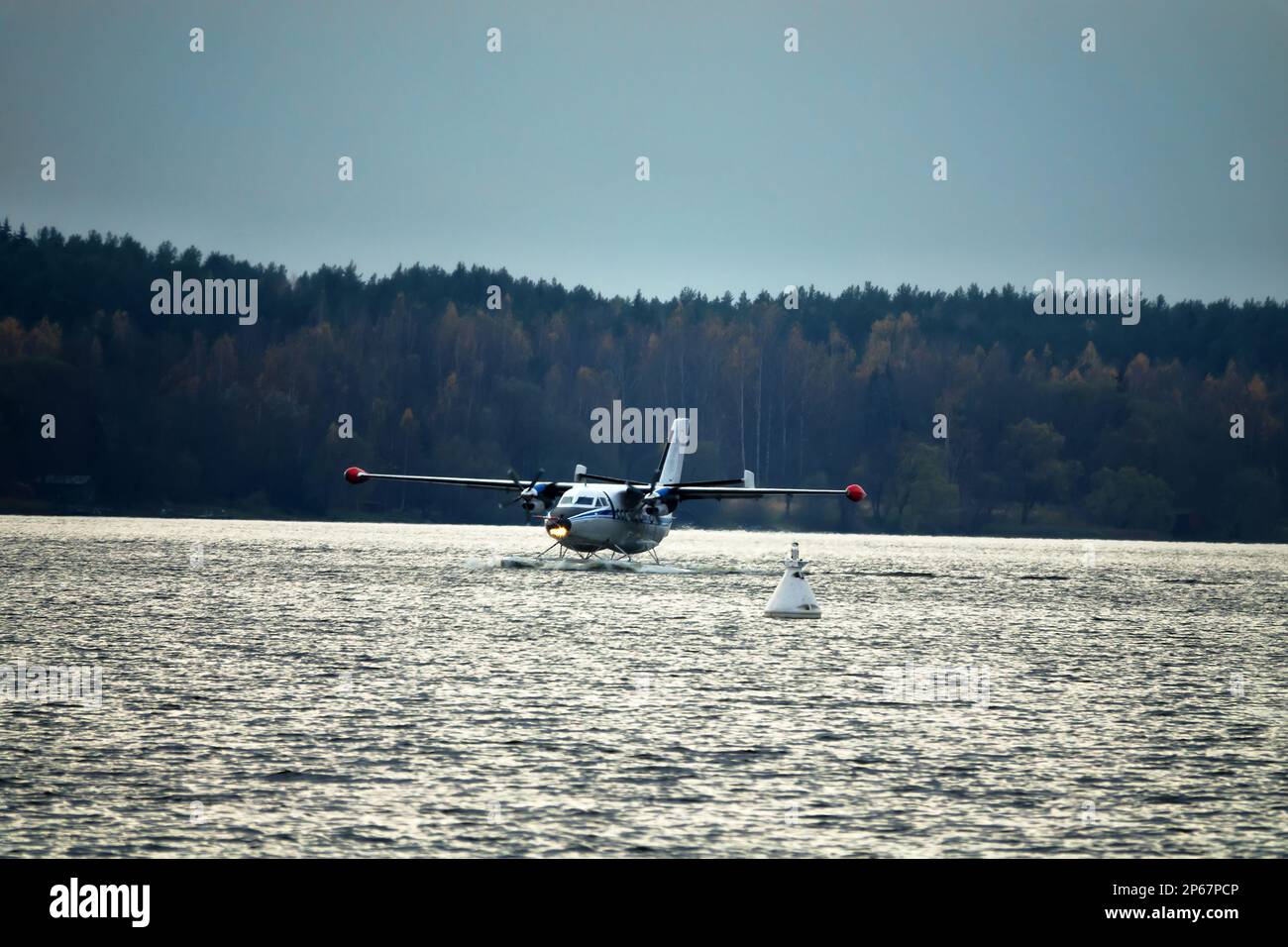 The Twinengine seaplane a seaplane rises from water, from the forest