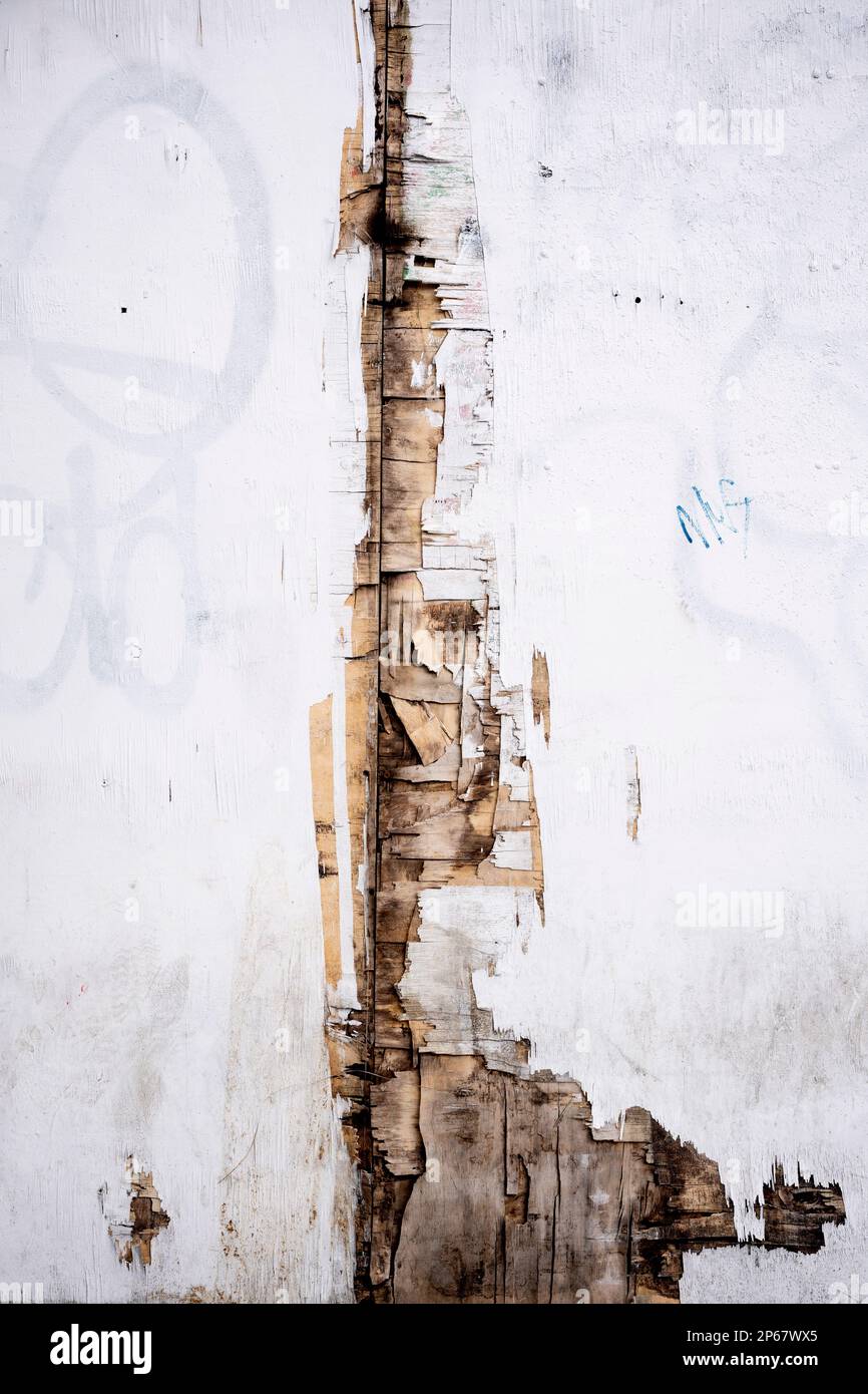 A detail of a peeling, split surface of a property's hoarding that represents closure and decay over the years in Cricklewood, on 6th March 2023, in London, England. Stock Photo