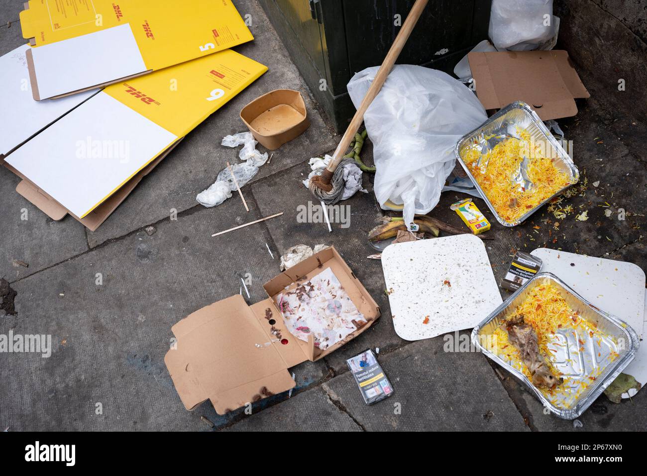 Packaging litter and food waste is spread across the pavement in a Cricklewood side street, on 6th March 2023, in London, England. Stock Photo