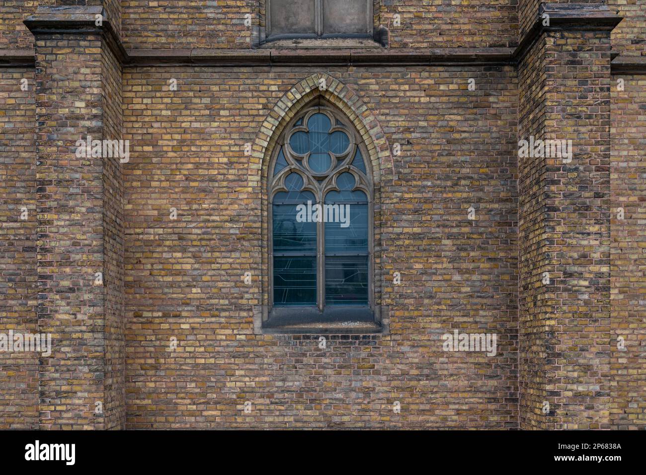 Ancient brick wall of a church with a large arched window in the middle ...