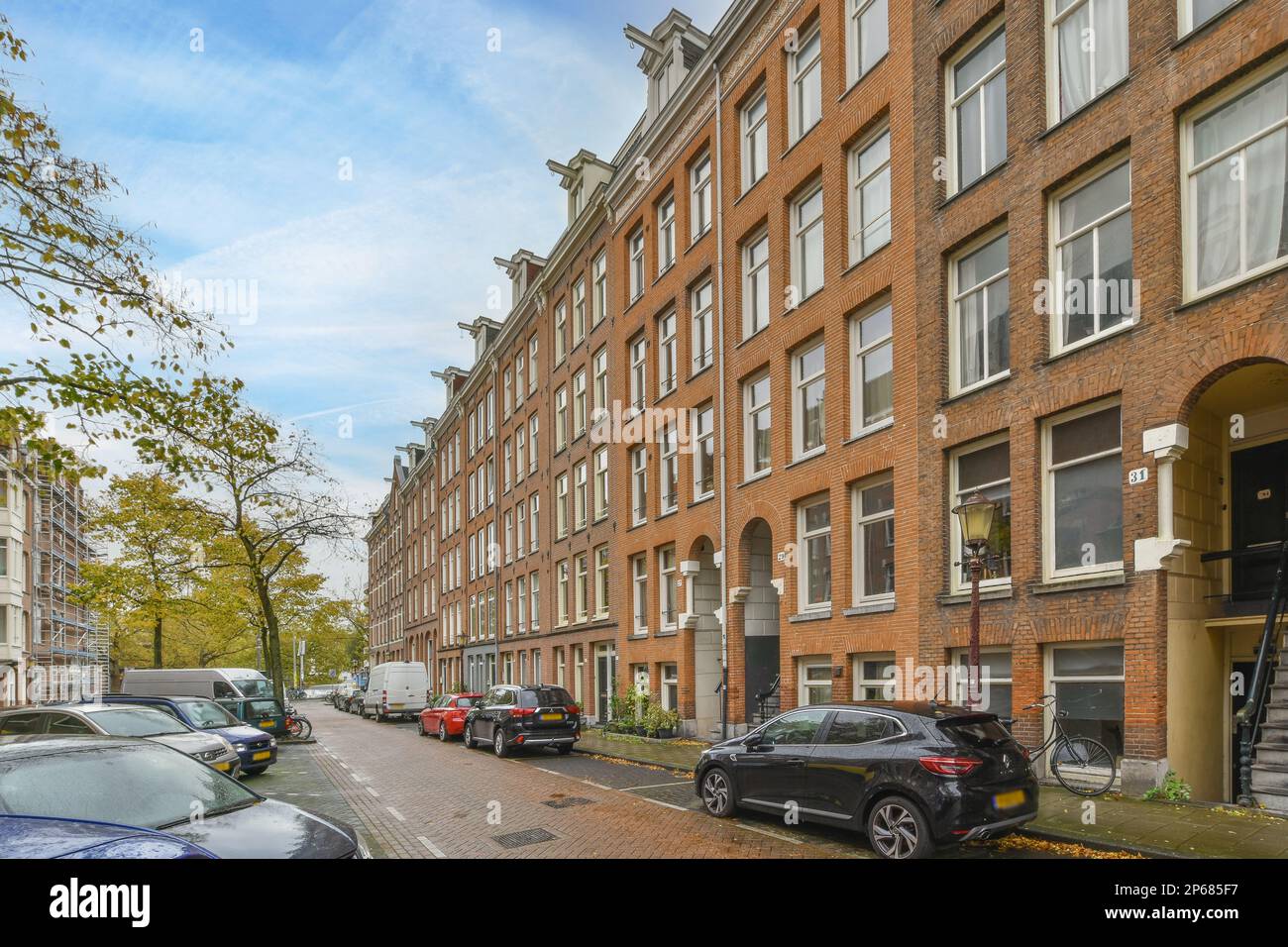 some cars parked on the side of a street in an urban area with tall ...