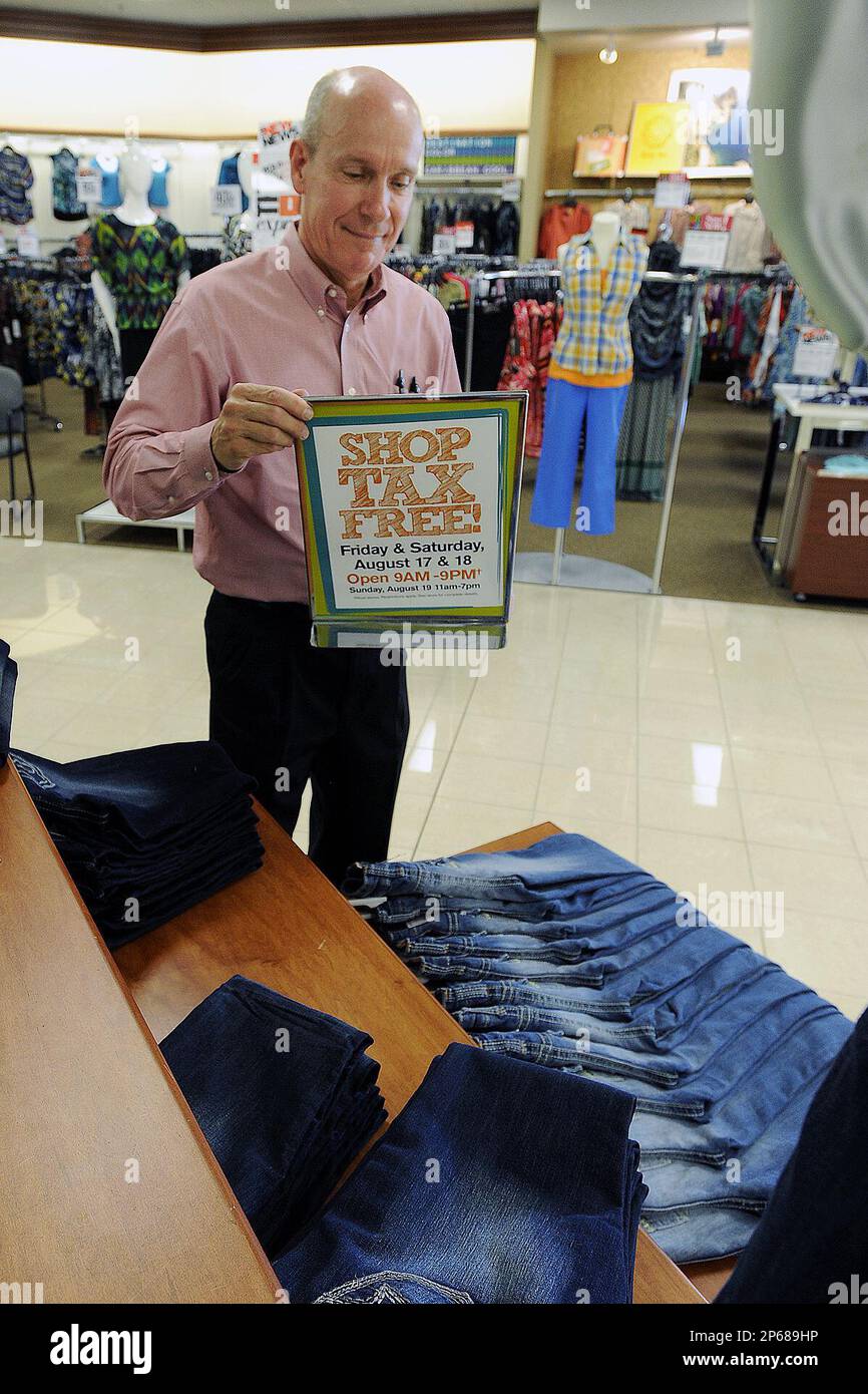 Store Manager Mike Mayfield places a sign on a bluejean display