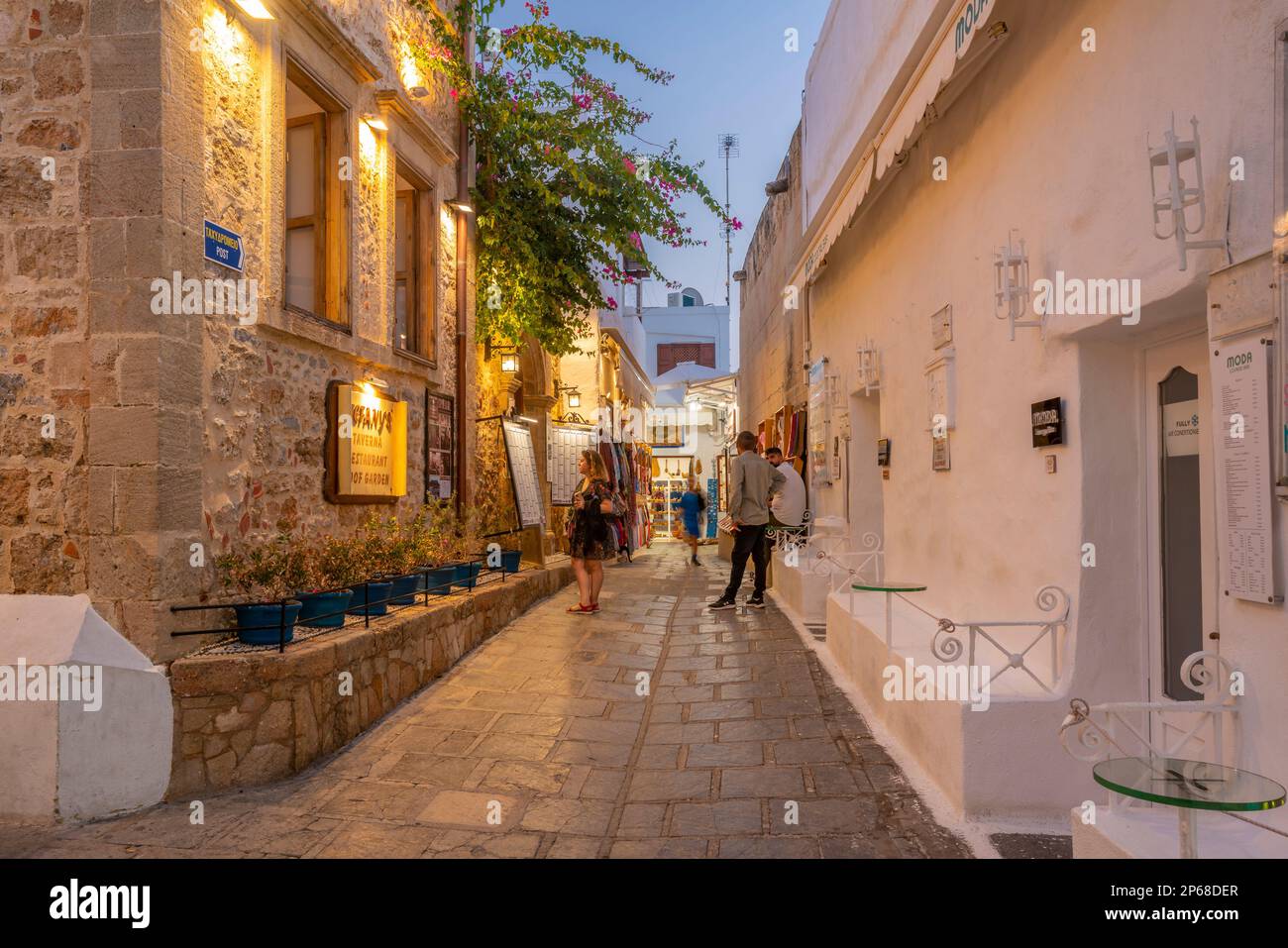 View of bar in Lindos street at dusk, Lindos, Rhodes, Dodecanese Island Group, Greek Islands, Greece, Europe Stock Photo