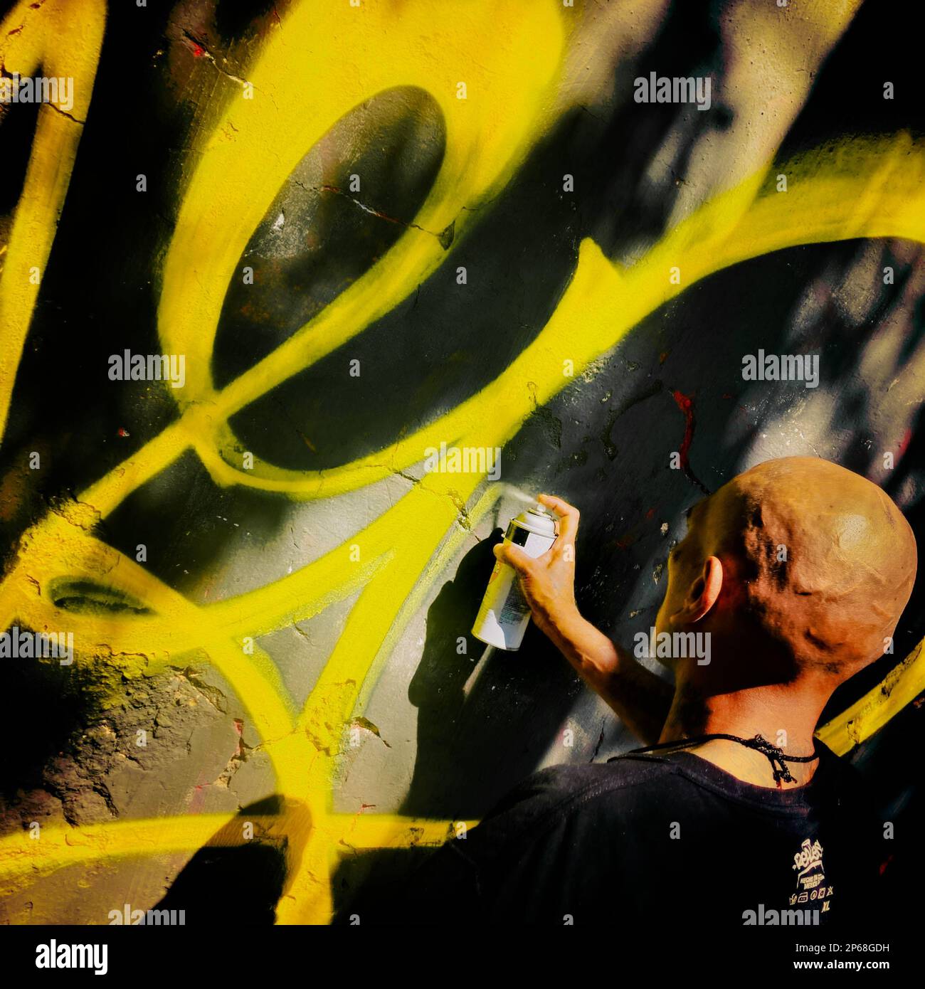 A Mexican street artist paints graffiti on the wall of a cemetery during a graffiti event in Guadalajara, Mexico. Stock Photo