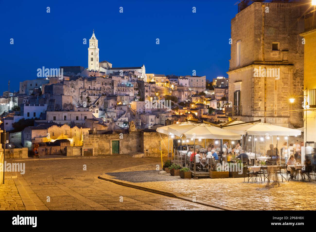 Restaurant at night with the Sassi di Matera old town floodlit, UNESCO World Heritage Site, Via D'Addozio, Matera, Basilicata, Italy, Europe Stock Photo