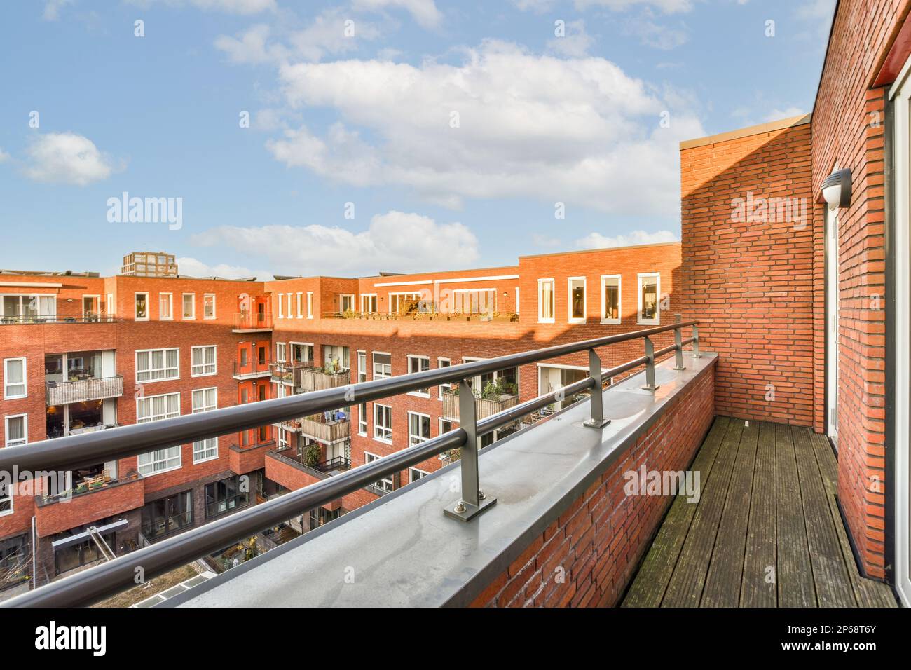 a balcony with red brick buildings and blue sky in the background ...