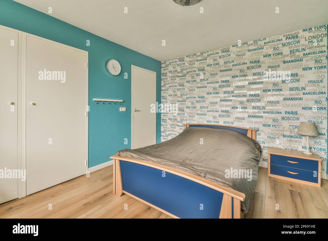 a bedroom with blue and white wallpaper on the walls, wood floors and a ...