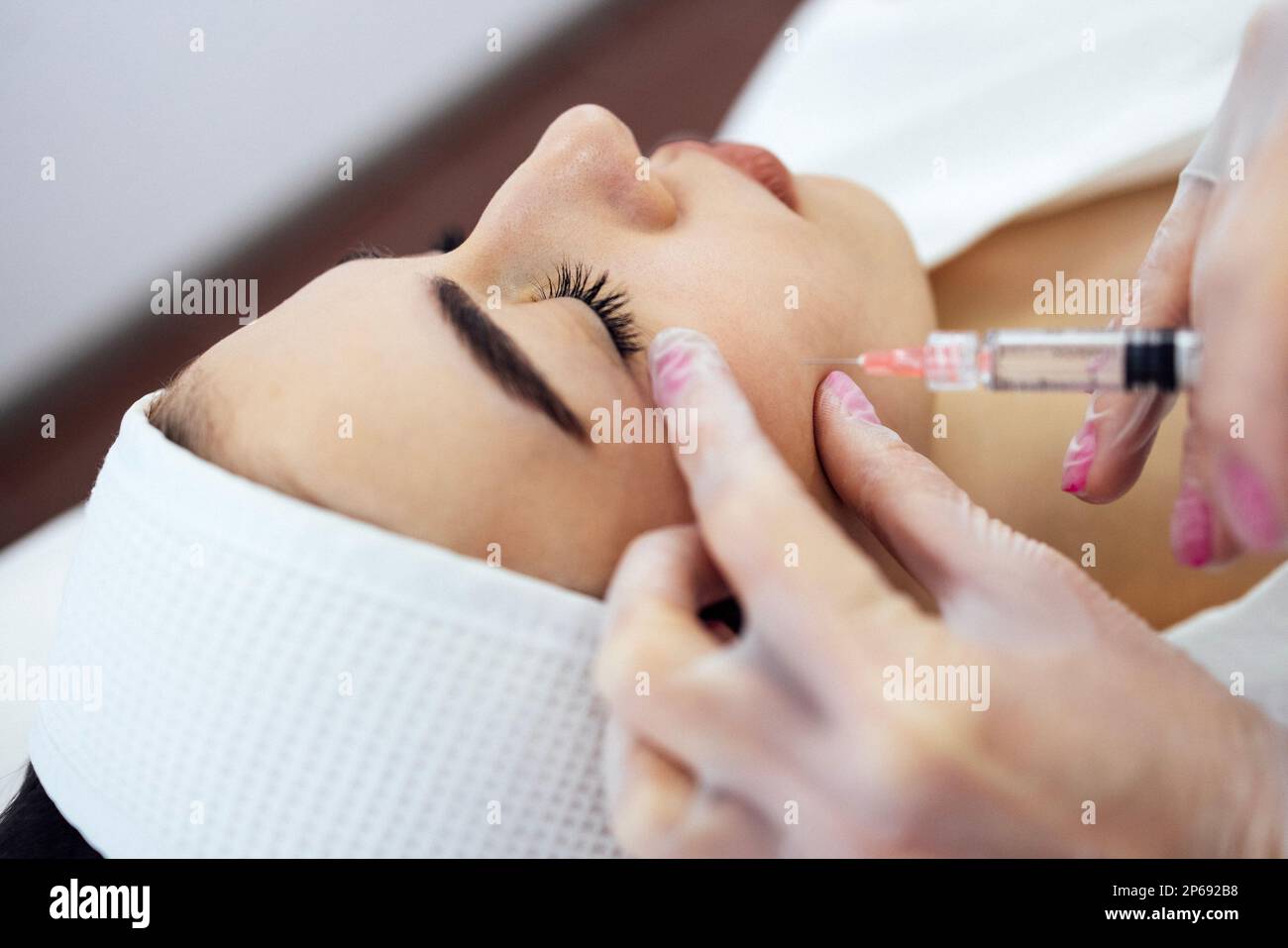 Beauty injections. Female cosmetologist in transparent gloves makes an ...